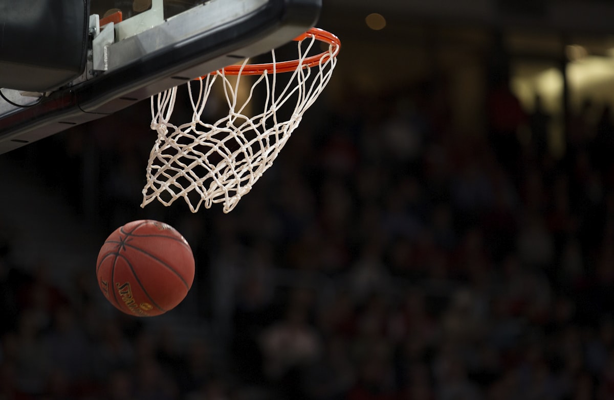 A basketball follows a parabolic path toward the hoop